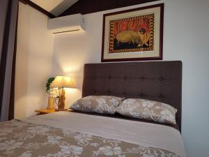 a bedroom with a bed and a picture of an elephant at O'hale Perry in Pirae