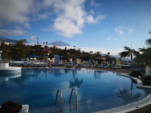 une grande piscine avec des chaises et des montagnes en arrière-plan dans l'établissement Casa Alena, à Santa Úrsula