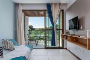 a living room with a bed and a sliding glass door at Residence in Barra de São Miguel