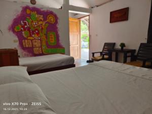 1 dormitorio con 2 camas y un cuadro en la pared en Lunazul Eco-Cabaña Frente al Mar en Mahahual