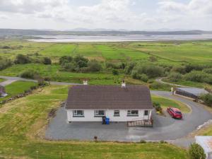 an aerial view of a white house with a driveway at Maggie's House in Glenties