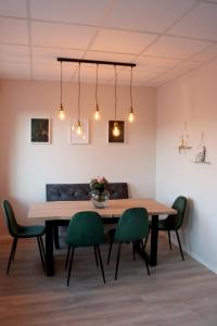 Apartment im Herzen der Stadt في براونشفايغ: غرفة طعام مع طاولة خشبية وكراسي خضراء