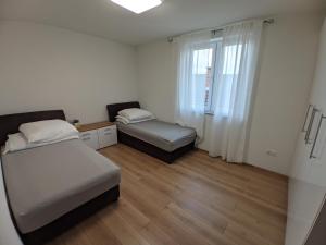 um pequeno quarto com 2 camas e uma janela em Ika LuX apartmani 4* em Sjenica