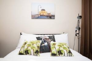 a bedroom with a bed with two pillows and a pier at Joli Light Filled Delight Close to the MCG in Melbourne