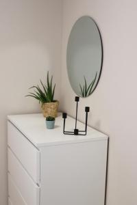 a white dresser with a mirror on top of it at Apartment im Herzen der Stadt in Braunschweig