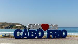 Un panneau qui dit aloha los cabosarios sur une plage dans l'établissement Cabo Frio - Hospedagem Central - Aluguel Econômico, à Cabo Frio