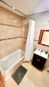 y baño con bañera blanca y lavamanos. en AlóUshuaia en Ushuaia