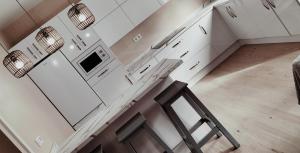 uma cozinha com armários brancos, um balcão e um banco em Apartamento zafra Cristina em Zafra