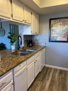 a kitchen with white cabinets and a sink at Lovely 1 bed condo near Lake Ray Hubbard in Garland