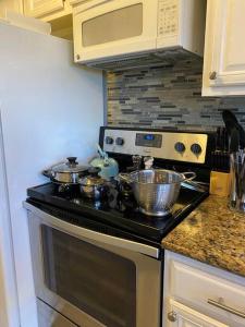 a kitchen with a stove with pots and pans on it at Lovely 1 bed condo near Lake Ray Hubbard in Garland