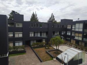 an exterior view of a black building with a courtyard at Lake 360 Apart Villa Carlos Paz in La Cuesta