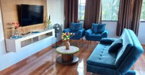 sala de estar con muebles azules y TV de pantalla plana en Residencial Recanto Paraíso BC - Cobertura, en Balneário Camboriú