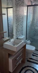 y baño con lavabo, aseo y espejo. en Residencial Recanto Paraíso BC - Cobertura, en Balneário Camboriú