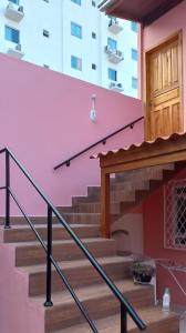 een trap in een gebouw met een roze muur bij Residencial Recanto Paraíso BC - Cobertura in Balneário Camboriú