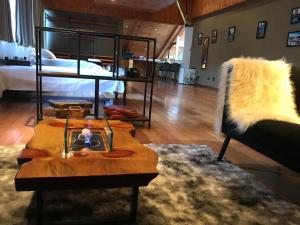 a living room with a bed and a coffee table at Capivari Lodge in Campos do Jordão