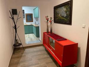 a red cabinet with vases on it in a kitchen at Rock House Villa in Drama