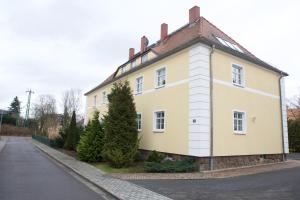 una grande casa bianca sul lato di una strada di Ferienwohnung Leipzig Süd a Markkleeberg