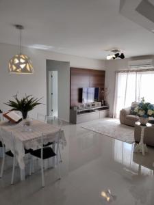 ein weißes Wohnzimmer mit einem Tisch und einem Sofa in der Unterkunft Apartamento Completo Família Gravata Navegantes SC Beto Carreiro in Navegantes