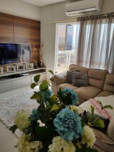 ein Wohnzimmer mit einem Sofa und einem TV in der Unterkunft Apartamento Completo Família Gravata Navegantes SC Beto Carreiro in Navegantes