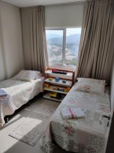 ein kleines Schlafzimmer mit 2 Betten und einem Fenster in der Unterkunft Apartamento Completo Família Gravata Navegantes SC Beto Carreiro in Navegantes