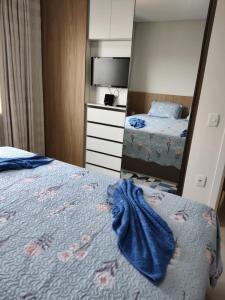 ein Schlafzimmer mit einem Bett und einem großen Spiegel in der Unterkunft Apartamento Completo Família Gravata Navegantes SC Beto Carreiro in Navegantes