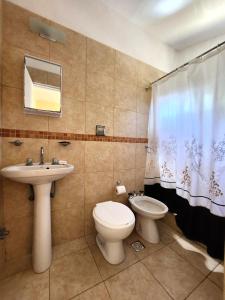 a bathroom with a toilet and a sink at Hotel Los Ángeles in San Clemente del Tuyú