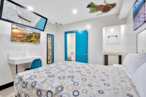 1 dormitorio con 1 cama grande y lavamanos en Royal Hawaiian Inn - Mid City, Los Angeles, en Los Ángeles