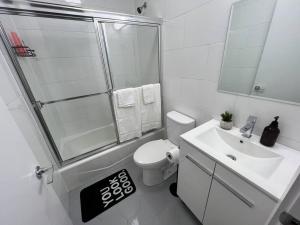 ein Bad mit einer Dusche, einem WC und einem Waschbecken in der Unterkunft Modern 2 bedroom apt w pool table in Heart of BKLYN in Brooklyn
