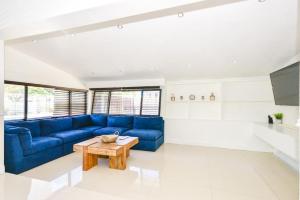 Una sala de estar con un sofá azul y una mesa. en Five Bedroom Villa With POOL In Highland Lakes Near Aventura Mall, en Miami