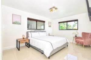 Un dormitorio blanco con una cama y una silla. en Five Bedroom Villa With POOL In Highland Lakes Near Aventura Mall, en Miami 31 fotos más