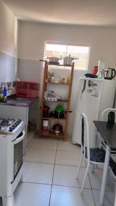 a small kitchen with a stove and a refrigerator at Apartamento em Pipa in Pipa