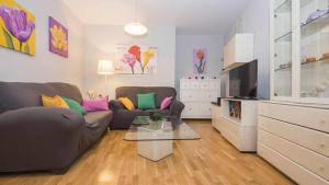 a living room with a couch and a tv at Apartamento Lorenzana by Toledo AP in Toledo