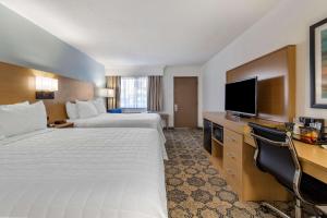Habitación de hotel con 2 camas y TV de pantalla plana. en Best Western Palm Beach Lakes en West Palm Beach