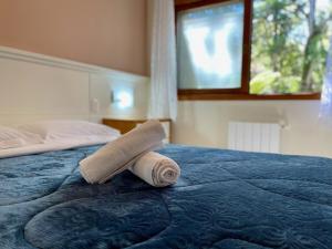 Una toalla enrollada encima de una cama en Apartamentos GRUNENBERG a 5 min do CENTRO by Achei Gramado, en Gramado
