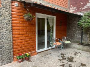 a patio with two chairs and a table in front of a building at La Casa del Molino Blanco B&B in Baños