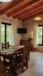 comedor con mesa de madera y sillas en Departamento Parras del Abuelo 2 en Malargüe