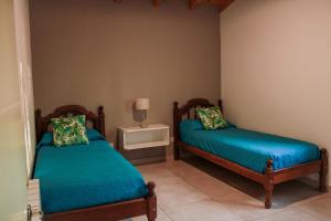 1 dormitorio con 2 camas y mesa con lámpara en Departamento Parras del Abuelo 2 en Malargüe