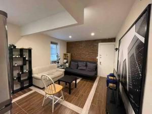 uma sala de estar com um sofá e uma televisão em New Apartament one Single Ride from Manhattan.. em Long Island City