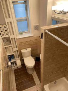 uma pequena casa de banho com um WC e uma janela em New Apartament one Single Ride from Manhattan.. em Long Island City