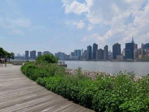 a wooden boardwalk with a view of a city at New Apartament one Single Ride from Manhattan.. in Long Island City