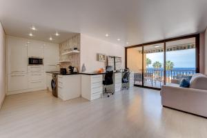 a kitchen and living room with a view of the ocean at BuenaVista Lago La Arena in Puerto de Santiago