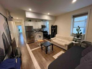 sala de estar con sofá y cocina en New Apartament one Single Ride from Manhattan.. en Long Island City