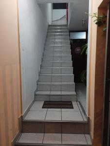 a stairway leading up to a hallway with white tiles at Tambo Huascar in Lima