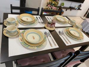 a table with plates and utensils on it at Sunway City Onsen COSY HOME Tambun Ipoh in Ipoh