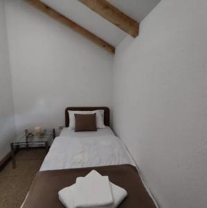 sypialnia z łóżkiem z dwoma białymi ręcznikami w obiekcie Green Paradise Kolašin w mieście Kolašin
