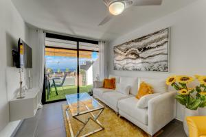 salon z białą kanapą i szklanym stołem w obiekcie BuenaVista Sunflower Apartment in Playa La Arena w mieście Puerto de Santiago
