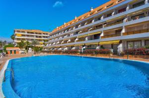 una gran piscina frente a un edificio en BuenaVista Sunflower Apartment in Playa La Arena en Puerto de Santiago