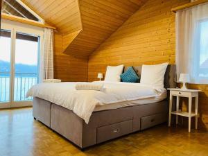ein Schlafzimmer mit einem großen Bett und einer Holzdecke in der Unterkunft Lake View Apartment - 12 in Niederried