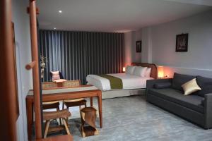 台南市にあるThe MSUG Hotelのベッドとソファのあるホテルの部屋