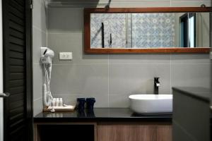 un bagno con lavandino e specchio di The MSUG Hotel a Tainan Altre 37 foto
